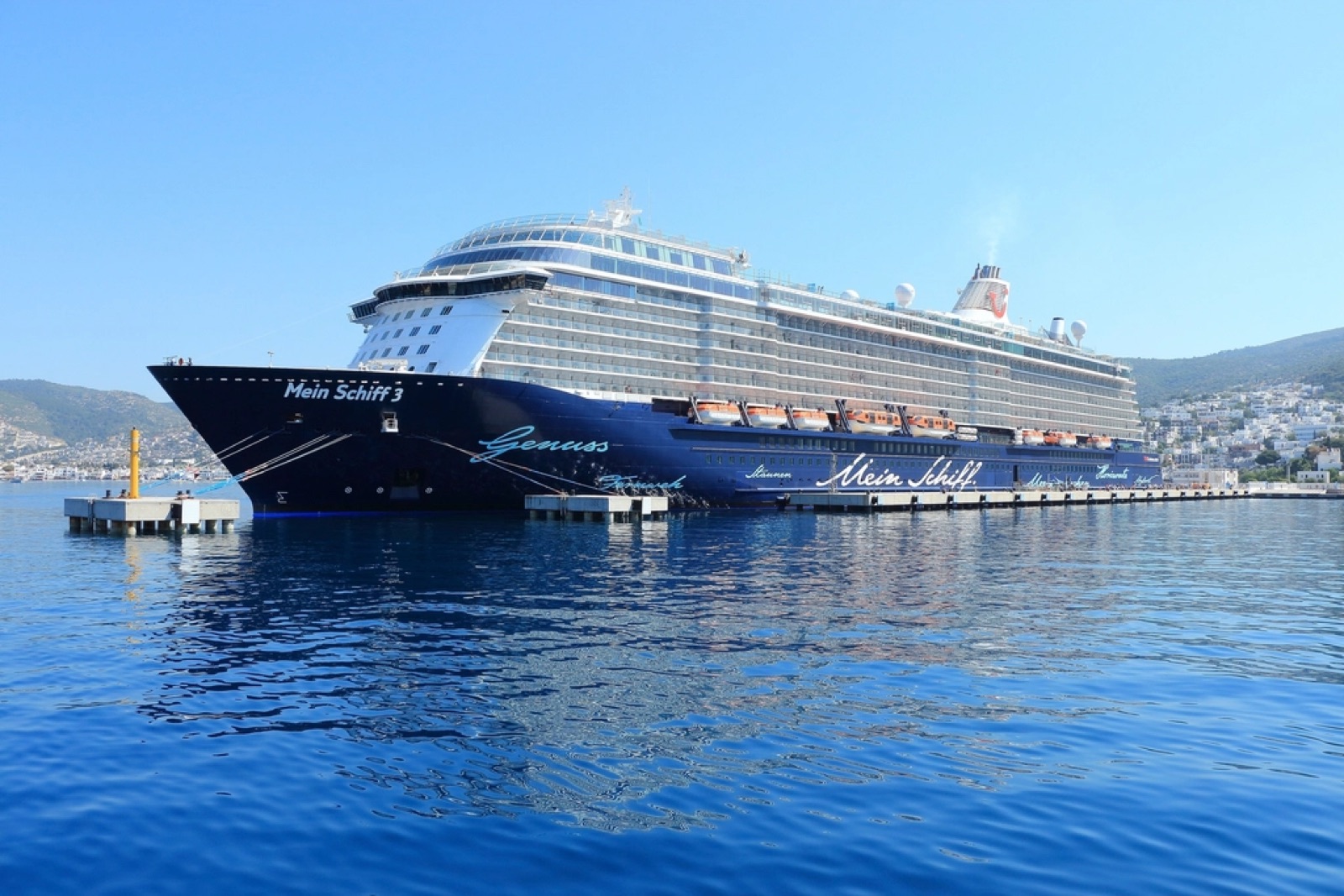 A large ocean cruise ship berthed on calm blue water