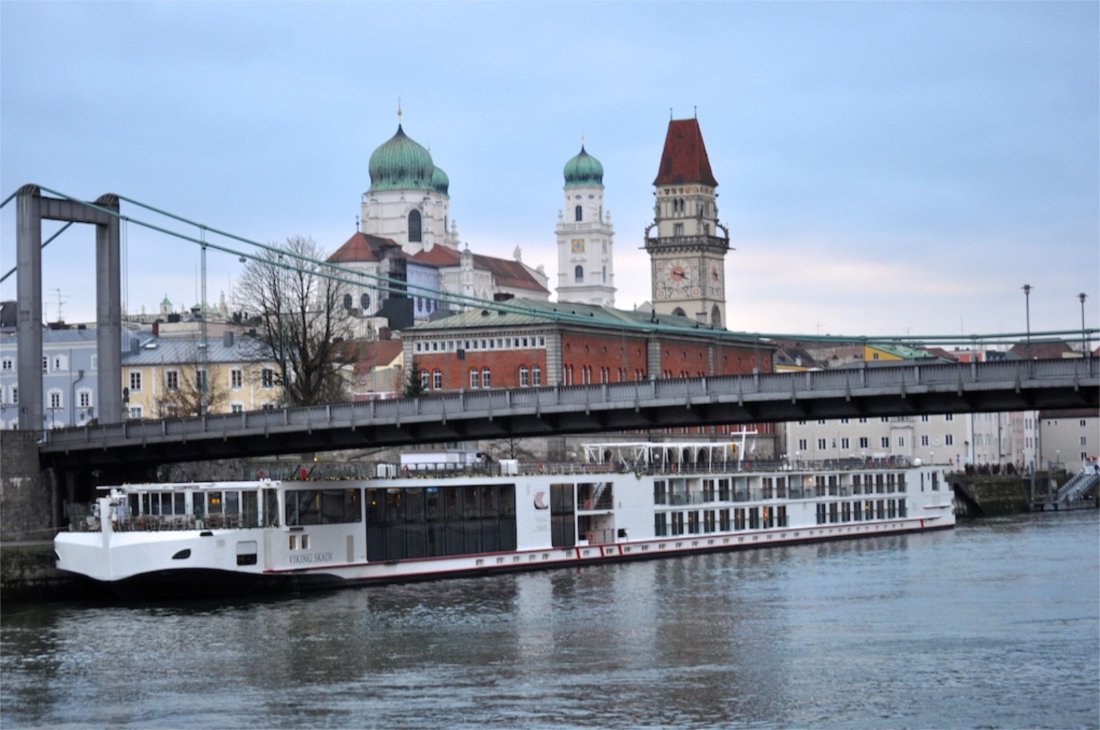 A river cruise ship moored below the old town and cathedral of Passau, Germany.