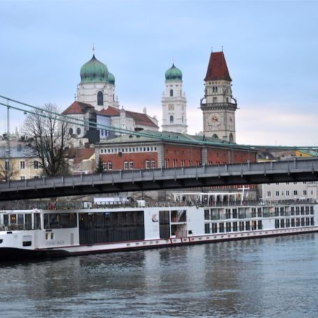A river cruise ship moored below the old town and cathedral of Passau, Germany.