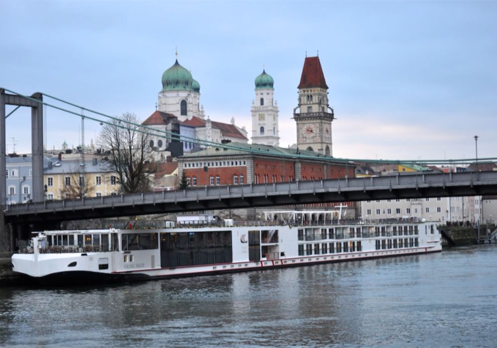 A river cruise ship moored below the old town and cathedral of Passau, Germany.